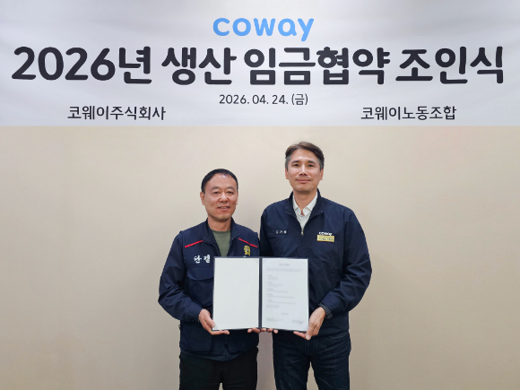 김기배 코웨이 생산구매본부장(오른쪽)과 임재환 생산 코웨이노동조합 위원장이 '2026년 임금협약 조인식'을 진행하고 기념 촬영을 하고 있다. [사진=코웨이]