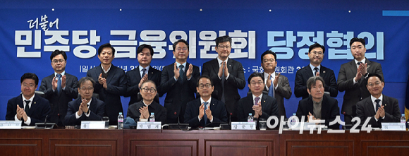 강준현 정무위원회 정조위원장과 이억원 금융위원장을 비롯한 의원들이 19일 국회 의원회관에서 중동사태 속 시장상황 점검 및 민생회복 지원 방안 논의를 위해 열린 더불어민주당 정무위원회-금융위원회 당정협의에서 기념촬영을 하고 있다. [사진=곽영래 기자]