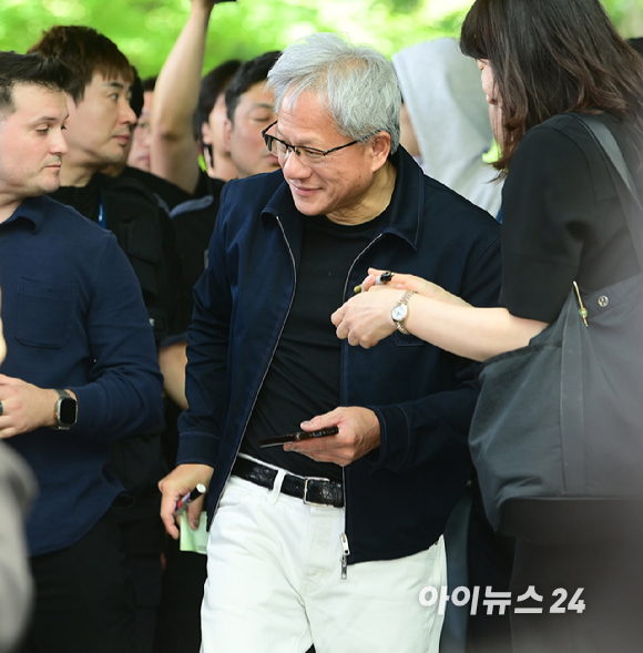 젠슨 황 엔비디아 최고경영자(CEO)가 5일 오후 전세기를 통해 서울김포비즈니스항공센터로 입국해 시민들의 사인 요청에 응하고 있다. 한 시민이 만원권 지폐에 사인을 요청하자 주머니에 넣을려는 유머스러운 제스쳐을 하며 웃는 젠슨 황의 모습. [사진=정소희 기자]