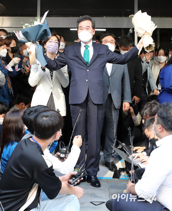 이낙연 전 더불어민주당 대표가 14일 오후 서울 여의도 대산빌딩에서 열린 필연캠프 해단식을 마친 뒤, 꽃다발을 들고 지지자들을 향해 손을 들고 있다.