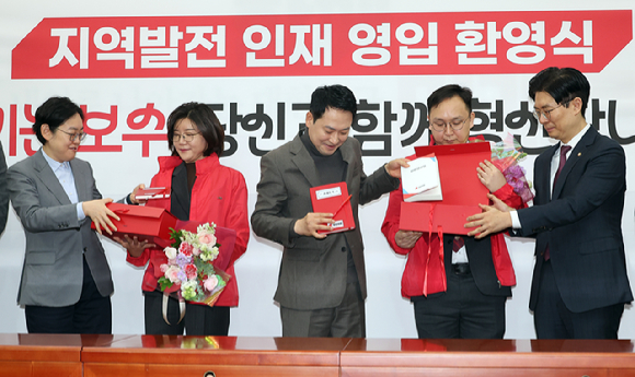 국민의힘 장동혁 대표가 25일 국회에서 열린 지역발전 인재영입 환영식에서 손정화 삼일회계법인 이사(왼쪽 두 번째), 정진우 현대엔지니어링 에너지영업팀 책임매니저(오른쪽 두 번째)에게 '시크릿 박스'를 전달한 뒤 내용물을 설명하고 있다. '시크릿 박스'에는 국민 목소리를 듣고 기록하는 경청노트와 펜, 당헌당규집과 당 뱃지, 국민과 함께 눈비 맞으며 국민 일상 챙겨달라는 의미의 우산과 시계가 들어있다. 2026.2.25 [사진=연합뉴스]