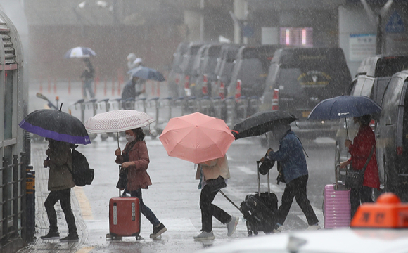 5월 4일 오전 제주국제공항 1층 도착장에 우산을 쓴 관광객들이 발걸음을 재촉하고 있다.  [사진=뉴시스]