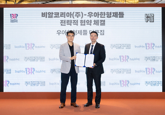 김지훈(오른쪽) 우아한형제들 사업부문장과 윤문건 배스킨라빈스 커머스마케팅실장이 지난달 서울 송파구 우아한형제들 본사에서 전략적 업무 협약(MOU)을 체결한 뒤 기념 촬영을 하고 있다. [사진=우아한형제들]