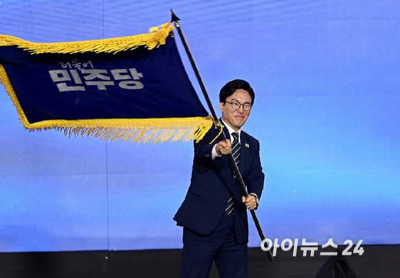 김민석 더불어민주당 신임 당 대표가 17일 대전 컨벤션센터에서 열린 제3회 더불어민주당 정기 전국당원대회에서 당 대표로 선출된 뒤 당기를 흔들고 있다. [사진=곽영래 기자]