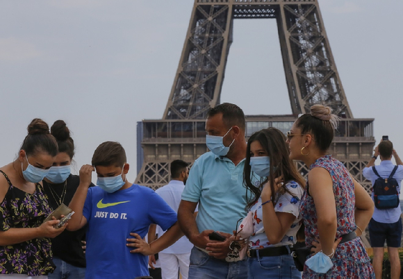 파리 에펠탑 앞에서 마스크를 착용한 관광객들이 모여 이야기를 나누고 있다.  [사진=뉴시스]