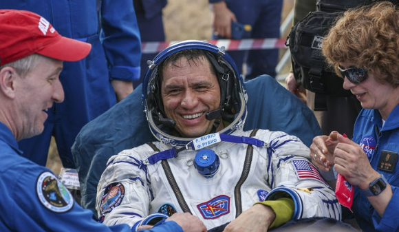 27일 카자흐 스텝에 귀환한 우주비행사 3명 중 한 명인 미국 나사의 프랭크 루비오가 러시아 로스코스모스 귀환팀과 악수하고 있다. [사진=AP/뉴시스]