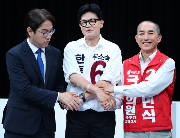 28일 오후 부산 동구 부산 MBC에서 열린 북갑 보궐선거 후보자 토론회에서 더불어민주당 하정우(왼쪽부터), 무소속 한동훈, 국민의힘 박민식 후보가 토론에 앞서 손을 맞잡고 있다. 2026.5.28 [사진=연합뉴스]