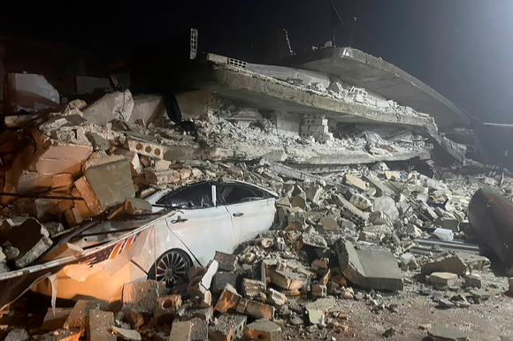 지난 6일(현지시간) 튀르키예 남부 지카흐라만마라슈주 인근에서 발생한 규모 7.8의 강진으로 시리아 이들리브주 아즈마에 있는 건물이 무너져 차량이 깔려 있다. [사진=뉴시스]