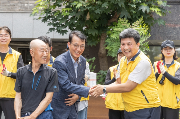 최홍연 송파구 부구청장(왼쪽)과 강경민 HDC현대산업개발 도시정비부문 부문장(오른쪽)이 독거노인 가구를 위한 주거환경 개선 건축봉사활동 후 악수를 하고 있다. [사진=HDC현대산업개발]