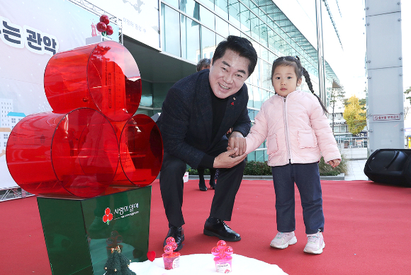 모금함에 기부하러온 아이와 기념 사진 촬영하는 박준희 관악구청장. [사진=관악구]