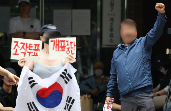 제9회 전국동시지방선거 및 국회의원 재&middot;보궐선거 투표용지 부족으로 투표 시간이 오후 10시까지 연장됐던 서울 송파구 잠실7동 제2투표소 앞에서 4일 투표함 반출에 반대하는 시민들이 구호를 외치고 있다. [사진=연합뉴스]