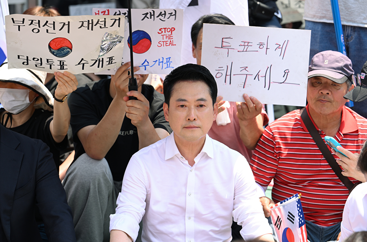 6&middot;3 지방선거 투표용지 부족 사태로 촉발된 잠실 개표소 봉쇄 시위가 이어진 16일 국민의힘 장동혁 대표가 서울 송파구 올림픽공원 핸드볼경기장 개표소 앞에 자리를 잡고 앉아 있다. 2026.6.16 [공동취재] [사진=연합뉴스]