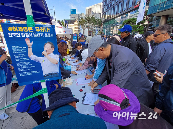 2일 서울역 인근에서 진행된 '김건희·윤석열 국정농단 규탄·특검촉구 국민행동의 날' 집회장 한편에 마련된 부스에서 '이재명 대표 무죄 판결 탄원서 서명 운동'을 진행하는 모습. [사진=라창현 기자]