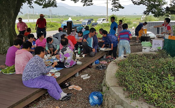 전라남도 장흥군 관산읍 남송1구 주민들이 ' 농번기 마을공동급식 지원사업'으로 함께 모여 식사를 하고 있다. [사진=전남도]