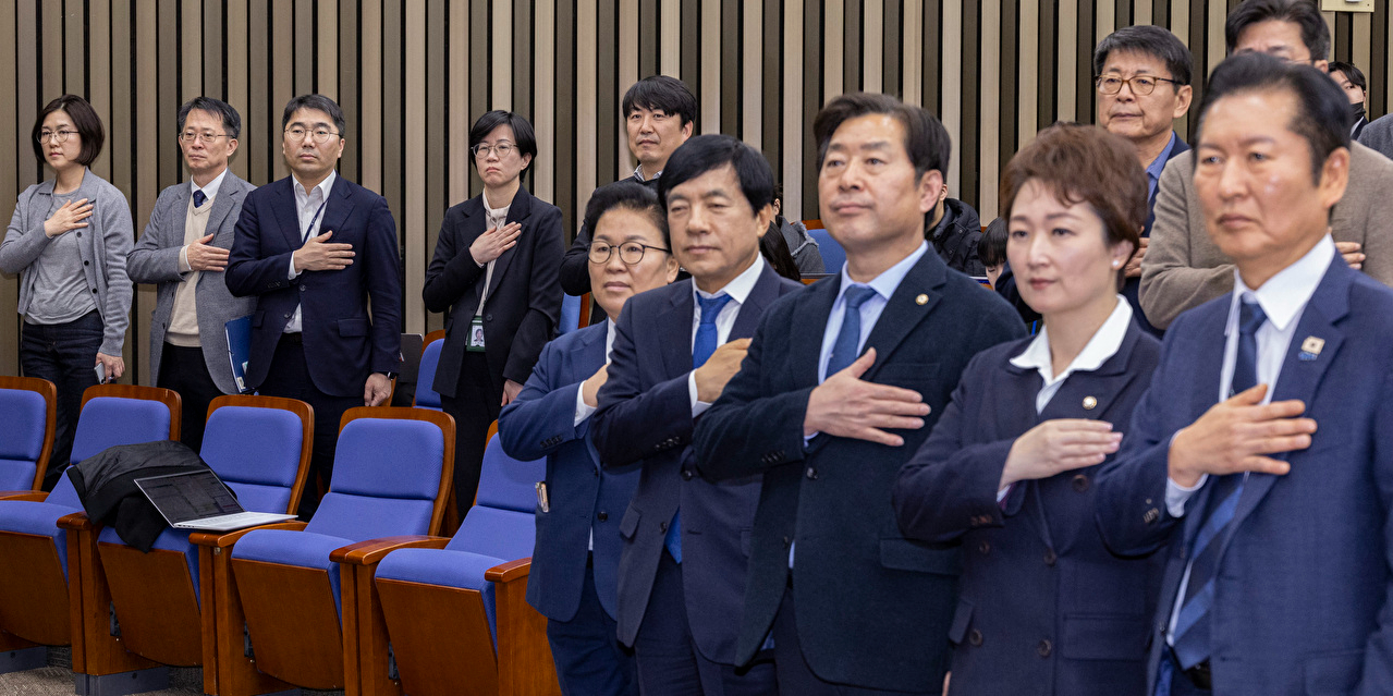 5일 국회에서 열린 더불어민주당 정책 의원총회에 공소청법&middot;중수청법에 대한 정부안을 설명하기 위해 국무총리실 산하 검찰개혁추진단 관계자들이 국기에 경례하고 있다. 2026.2.5 [사진=연합뉴스]
