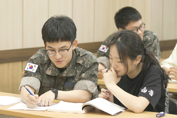 KT희망나눔인상 공동 수상자인 공군 제15특수임무비행단 교육봉사 동아리 소속 장병이 멘토링 학생을 가르치는 모습. [사진=KT]