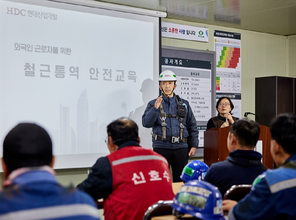 20일 HDC현대산업개발 관계자가 잠실진주재건축현장에서 외국인 근로자 대상 안전교육을 하고 있다. [사진=HDC현대산업개발]