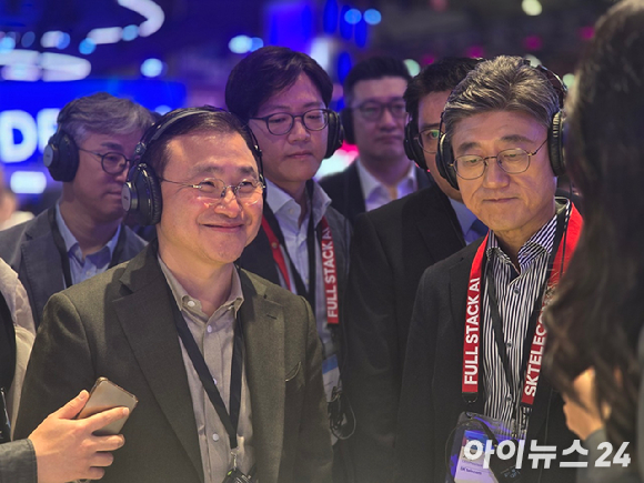 정재헌 SK텔레콤 최고경영자(CEO, 앞열 우측 첫 번째)가 2일(현지시간) 스페인 바르셀로나 피아 그란비아 내 삼성전자 전시관에서 노태문 삼성전자 사장과 만나 부스 관계자로부터 전시관 설명을 듣고 있다. [사진=안세준 기자]