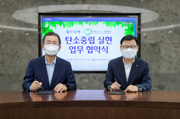 이원덕 우리은행장(오른쪽)이 한국기후환경네트워크 이우균 상임대표와 전자협약을 진행하고 기념촬영을 하고 있다. [사진=우리은행]