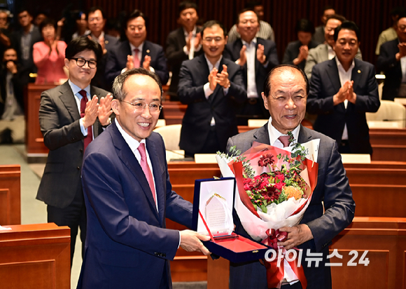 추경호 국민의힘 원내대표가 25일 오전 서울 여의도 국회에서 열린 의원총회에서 황우여 비상대책위원장에게 감사패를 전달하고 있다. [사진=곽영래 기자]