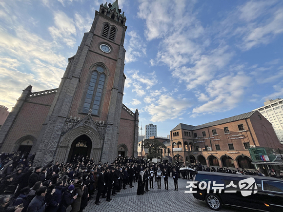 9일 서울 중구 명동성당에서 열린 故 안성기의 장례 미사가 끝난 뒤 영결식을 위해 고인의 영정과 금관문화훈장을 든 배우 정우성, 이정재가 영결식장으로 향하고 있다. [사진=곽영래 기자]