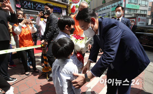 윤석열 대통령 당선인이 26일 인천 계양산전통시장을 방문해 어린이들에게 꽃을 받고 있다. [사진=인수위 사진기자단]