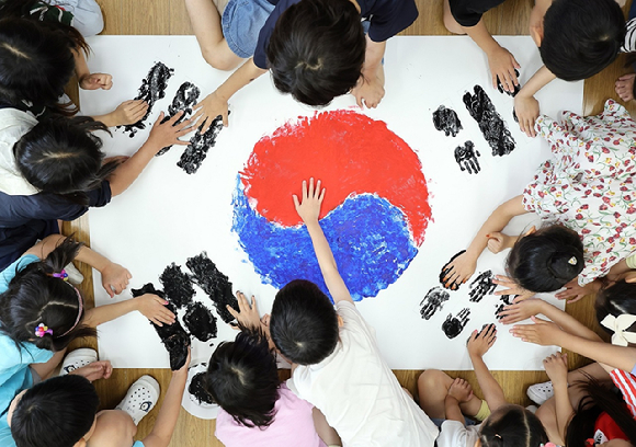 초등학교 학생들이 손바닥에 물감을 묻혀 태극기를 만들고 있다 [사진=연합뉴스]