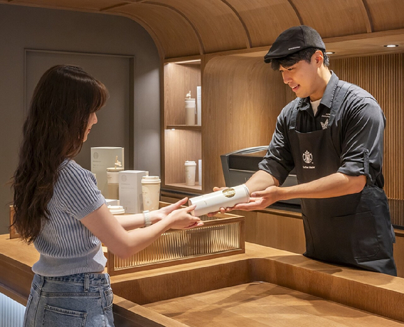 스타벅스 직원이 고객에게 개인 맞춤형'텀블러 각인 서비스'를 제공하고 있다. [사진=스타벅스코리아 제공]