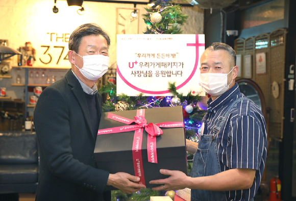 황현식 LG유플러스 사장(왼쪽)이 1차 캠페인을 통해 선정된 서울 강남구 소재 'THE 374'를 방문해 소상공인 사장님에게 선물을 증정하는 모습. [사진=LG유플러스]