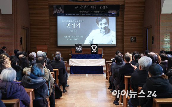 9일 서울 중구 명동성당에서 열린 故 안성기의 장례 미사가 끝난 뒤 영결식을 위해 고인의 영정과 금관문화훈장을 든 배우 정우성, 이정재가 영결식장으로 향하고 있다. [사진=곽영래 기자]