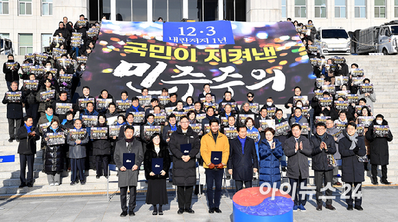 더불어민주당 정청래 대표와 김병기 원내대표, 의원들과 시민들이 3일 서울 여의도 국회 본관 앞 계단에서 열린 12.3 내란 저지 1년 현장 최고위원회의에서 기념촬영을 하고 있다. [사진=곽영래 기자]