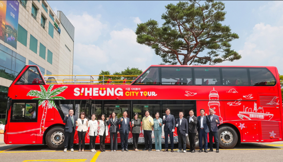 시티투어 2층 버스 시범 운행을 앞두고 지난 25일 시흥시 관계자 등이 기념 촬영을 하고 있다. [사진=시흥시]