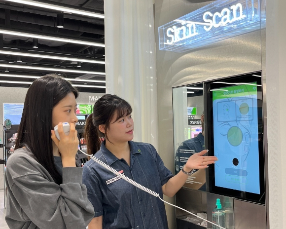 CJ올리브영 합정메세나폴리스점에 도입된 '스킨스캔' 기기에서 피부 측정을 하고 있는 모습. [사진=CJ올리브영]