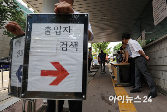 24일 윤석열 전 대통령의 내란 우두머리 혐의 관련 재판 12차 공판 기일이 열리는 서울 서초구 서울중앙지방법원 입구에 법원 보안 인력이 배치되어 있다.윤 대통령은 이날 재판부에 건강상의 사유로 출석하기 어렵다는 내용의 의견서를 제출하며 재판에 불출석했다. [사진=사진공동취재단]
