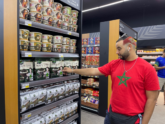 한 축구팬이 카타르 월드컵 경기장 팬 존(Fan Zone)에서 비비고 제품을 살펴보고 있다. [사진=CJ제일제당]