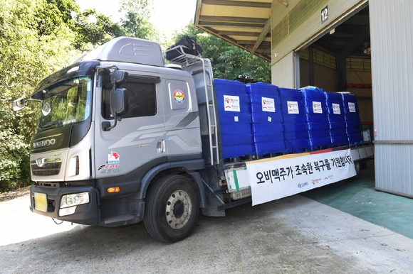 7일 오비맥주 생수를 실은 차량이 희망브리지 파주 물류센터에서 강원도 동해시청으로 출발하고 있다. [사진=오비맥주]