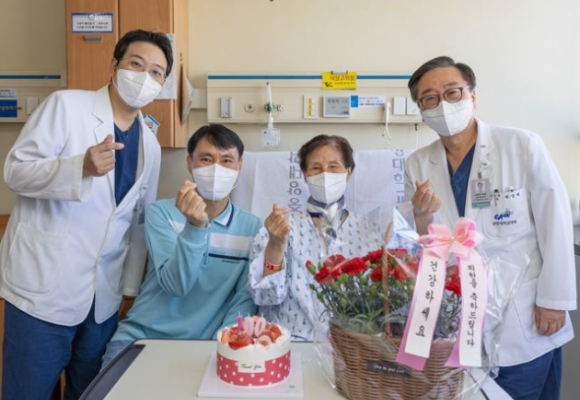 중앙대의료원 100번째 간 이식 수술을 마치고 기증자인 아들(사진 왼쪽에서 두 번째)과 수혜자인 어머니(사진 왼쪽에서 세 번째)가 의료진과 함께 건강한 모습으로 기념 촬영을 하고 있다. [사진=중앙대의료원]