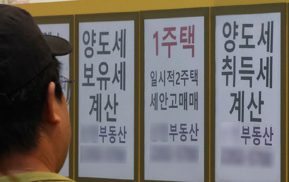 김용범 청와대 정책실장은 지난 20일 페이스북에 올린 글에서 "부동산 과세를 정상화해야 한다. 보유세와 양도세를 합리적으로 조정하는 것은 필요하고 옳은 방향"이라고 말했다. 사진은 이날 서울 송파구 한 부동산 중개업소에 붙은 세금 관련 안내문 모습. 2026.6.21 [사진=연합뉴스]