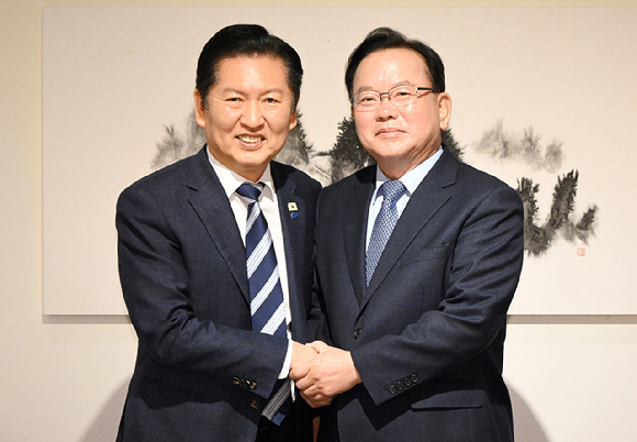 더불어민주당 정청래 대표와 김부겸 전 국무총리가 26일 서울 중구 달개비에서 회동 전 손을 맞잡고 있다. [사진=연합뉴스]