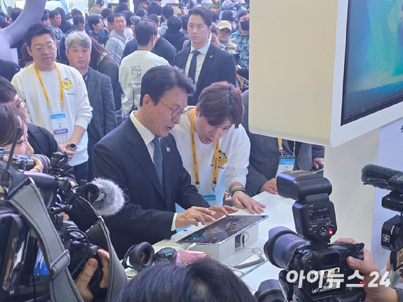 김민석 국무총리가 15일 부산 벡스코 '지스타 2025' 전시장을 방문해 넷마블 부스에서 설명을 듣고 있다. [사진=박정민 기자]