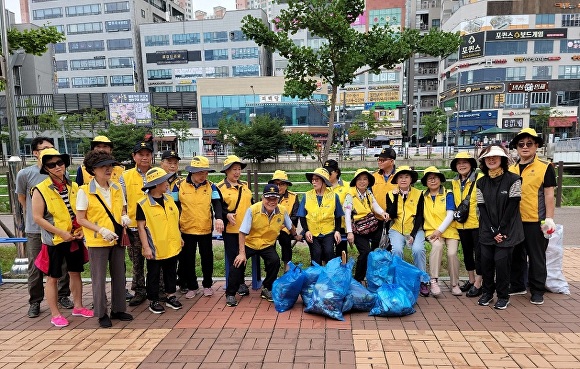 경기도 파주시 운정3동 실버경찰대원들이 함께 빗물받이 불청객 담배꽁초 제거 활동 후 기념촬영을 하고 있다. [사진=파주시]