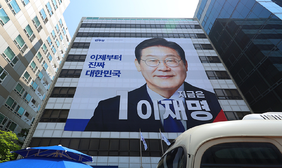 제21대 대통령선거 공식 선거운동 첫날인 지난 12일 서울 여의도 민주당사 외벽에 이재명 후보의 대형 사진이 걸려 있다. [사진=연합뉴스]