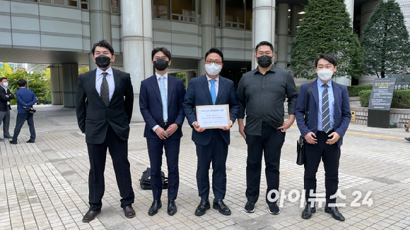  이용자 대표 김성수 씨(오른쪽)와 소송을 대리하는 신재연 변호사(가운데)가 23일 서울중앙지법 민원실 앞에서 고소장을 들고 있다.