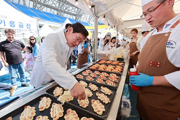 이상일 용인특례시장이 지난 28일 '2024 용인먹거리페스타' 백옥쌀 품은 빵페스타 부스에 방문해 시식을 해보고 있다. [사진=용인특례시]