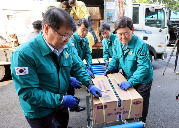 지난 12일 김광수(오른쪽 첫번째) 제주교육감과 교육청 관계자들이 제주에 도착한 수능 문답지를 보관 장소로 옮기고 있다.  [사진=연합뉴스]