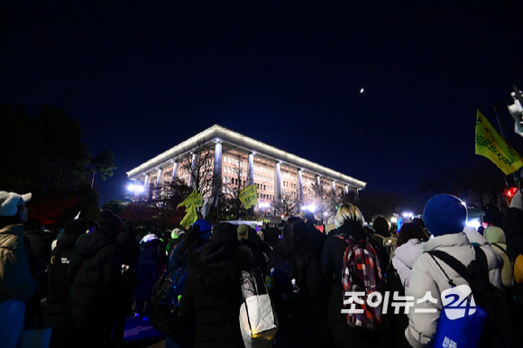 윤석열 대통령에 대한 탄핵소추안이 7일 국회 본회의에서 정족수 미달로 투표가 불성립된 가운데 윤 대통령 탄핵을 촉구하는 집회에 참석한 시민들이 집회가 끝난 후에도 국회를 둘러싸고 구호를 외치고 있다. [사진=정소희 기자]