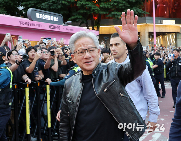 최태원 SK그룹 회장(왼쪽)과 젠슨 황 엔비디아 최고경영자(CEO)가 5일 서울 마포구 홍대 삼겹살집 '형님저요' 앞에서 SK하이닉스 HBM(고대역폭메모리) 과자칩을 들고 시민들과 소통하고 있다. [사진=정유림 기자]