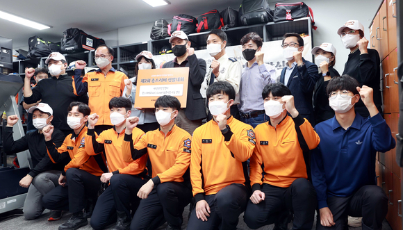 수원남부소방서 매산119안전센터에서 진행된 '제2회 촌스러버 선발대회' 치킨 나눔 활동의 참석자들이 단체사진을 촬영하고 있다. [사진=교촌F&B]