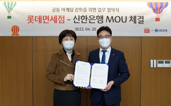 25일 서울시 중구 소재 롯데면세점 명동 본점에서 진행된 업무협약식에서 신한은행 김민수 외환본부장이(오른쪽) 롯데면세점 이상진 마케팅부문장과 기념촬영 하고 있다. [사진=한국은행]