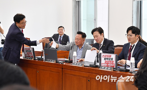 국민의힘 행정안전위원회 의원들이 18일 오전 서울 여의도 국회에서 열린 행정안전위원회 전체회의에서 노트북에 부착한 정원오 더불어민주당 서울시장 후보 관련 피켓을 제거하고 있다. [사진=곽영래 기자]